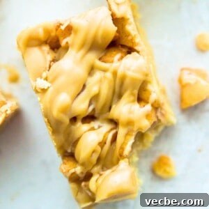 Apple Pie Bars Gluten Free Vegan and Paleo 17 A paleo apple pie bar with a bite out of it and pieces of cooked apples beside it.