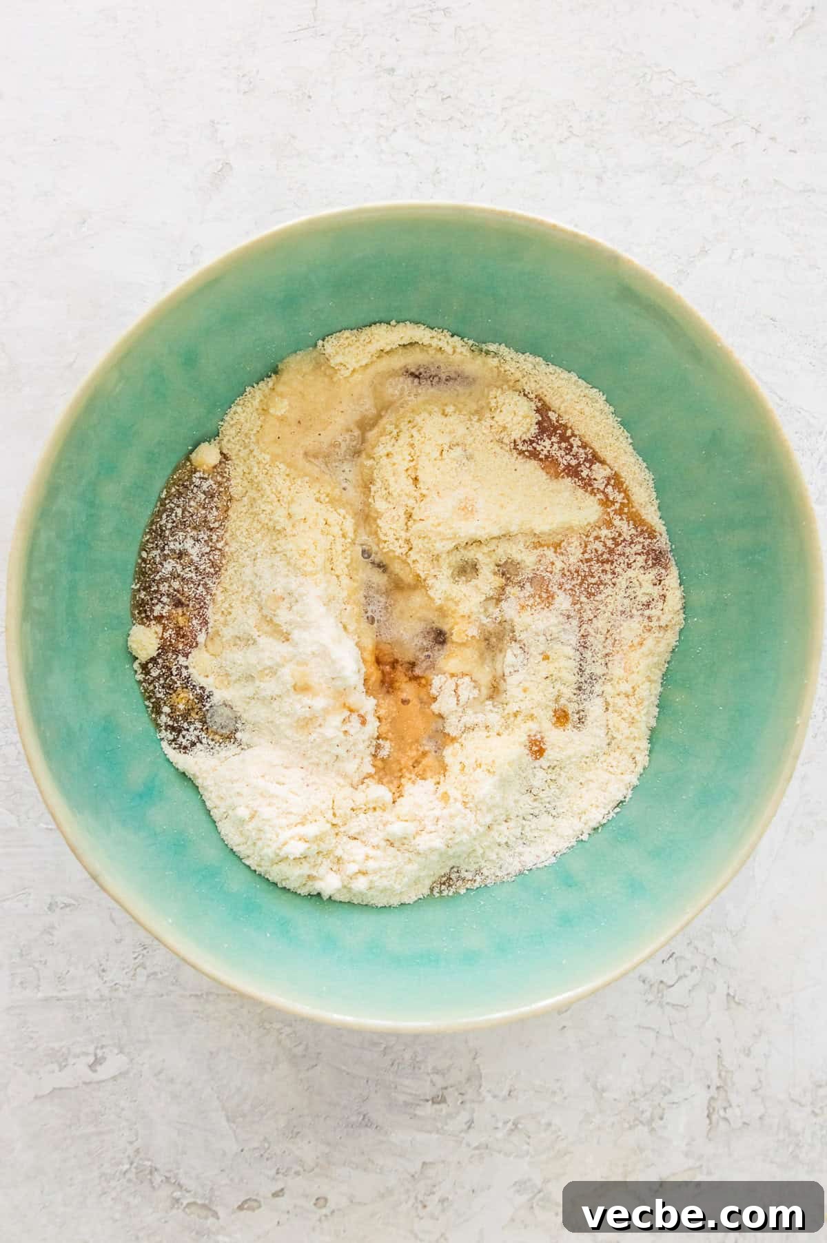 Apple Pie Bars Gluten Free Vegan and Paleo 4 A bowl with almond flour, honey, coconut oil, and coconut flour in it.