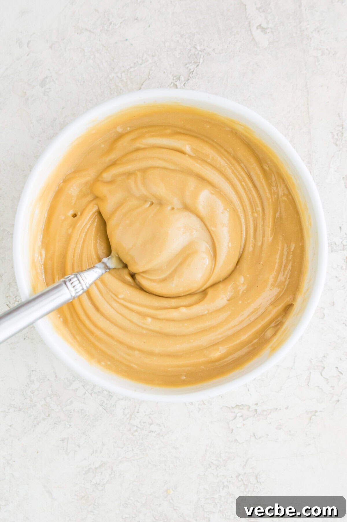 Apple Pie Bars Gluten Free Vegan and Paleo 7 A caramel sauce in a bowl with a spoon in it.