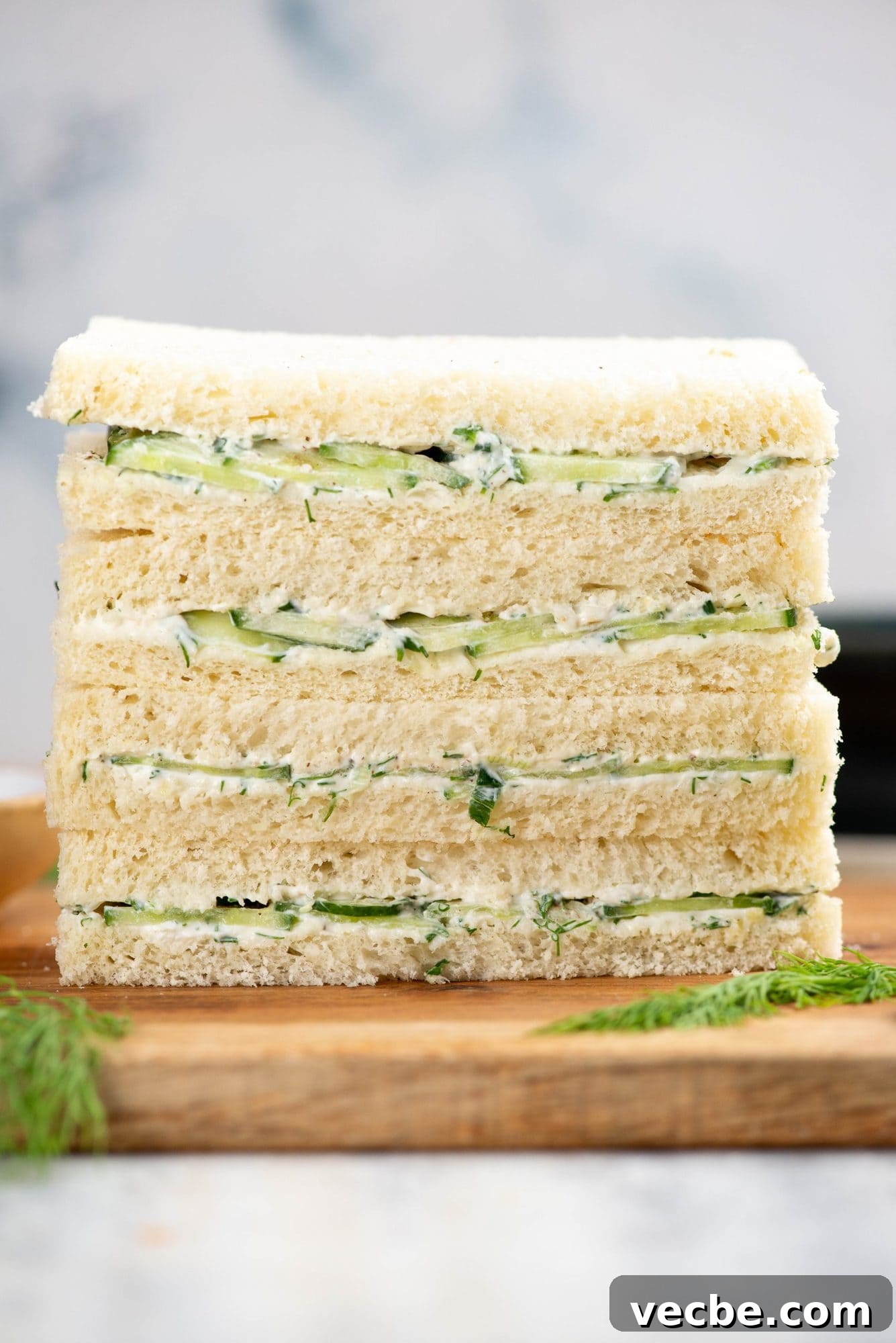 Classic Cucumber Tea Sandwiches with Cream Cheese 2 Stack of cucumber sandwiches with a creamy flavorful spread and sliced cucumber.