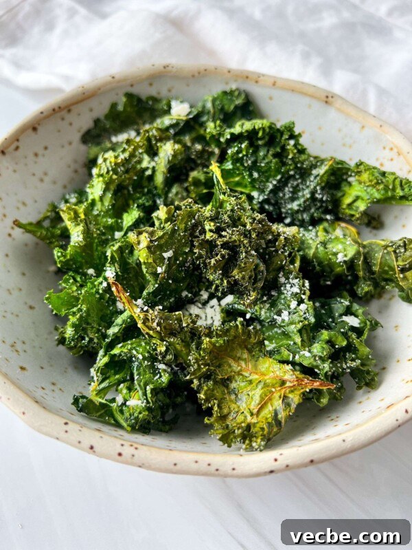 Caramelized Air Fryer Pineapple Recipe 4 A bowl of crispy Air Fryer Kale Chips sprinkled with grated cheese in a speckled ceramic dish.