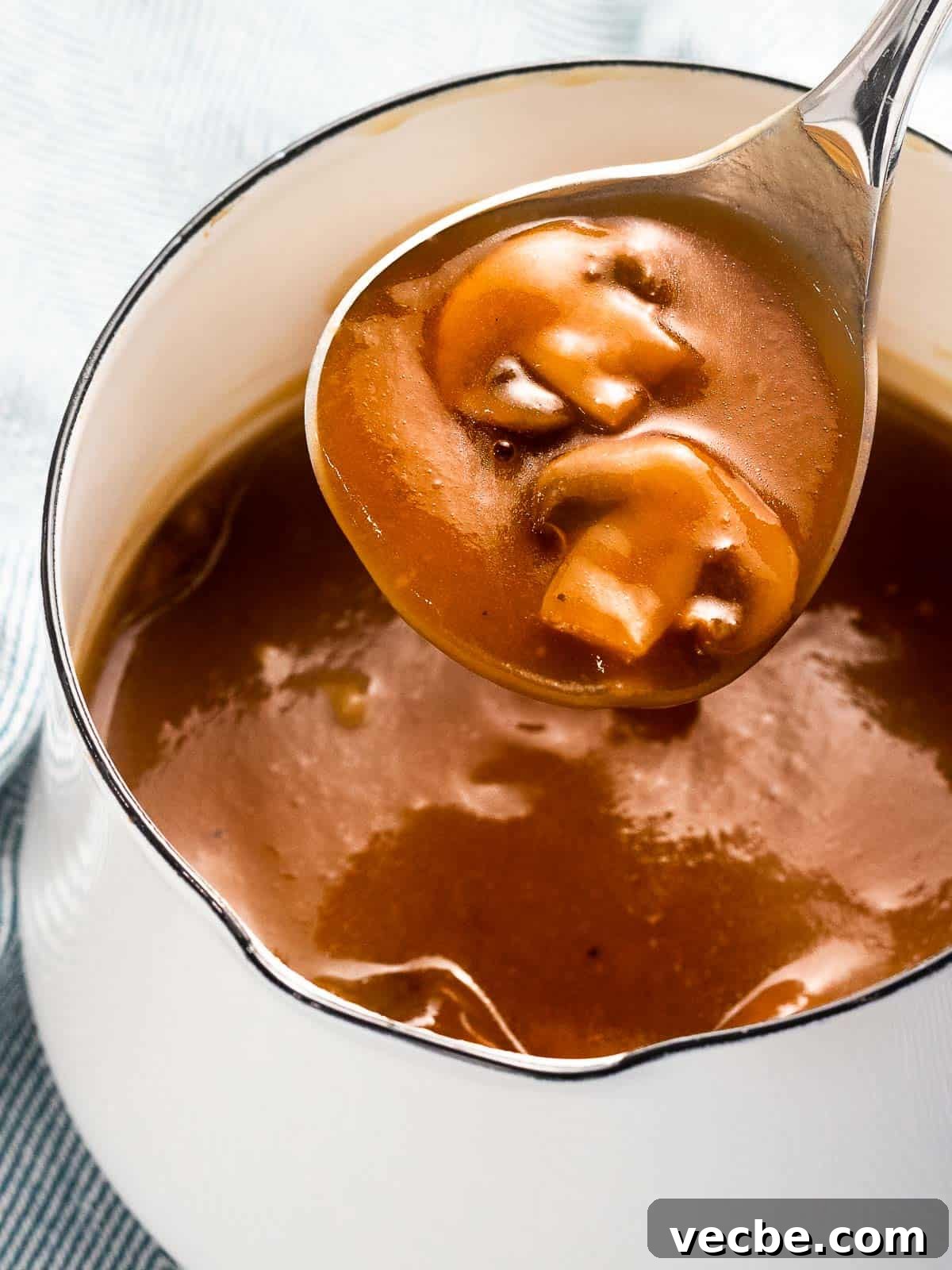 Homemade Mushroom Gravy Recipe for Roasts and Potatoes 2 Mushroom gravy with sautéed mushrooms in a pot.