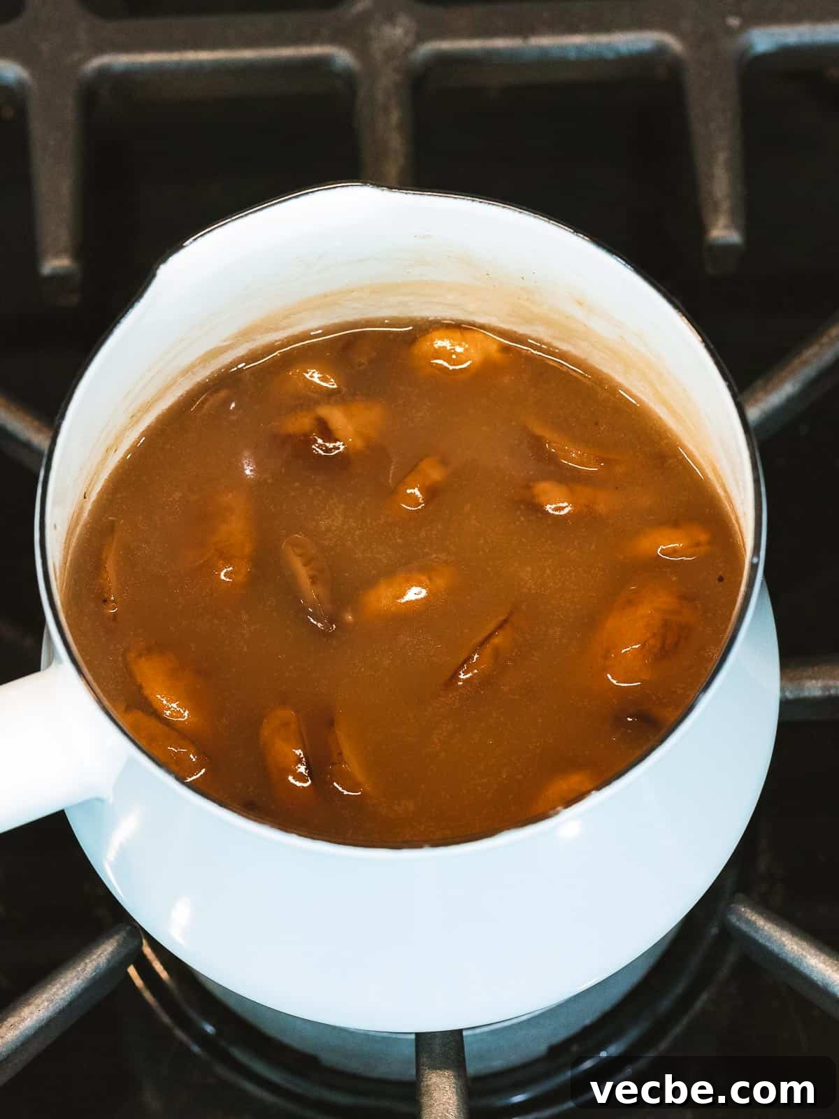 Homemade Mushroom Gravy Recipe for Roasts and Potatoes 5 Mushroom gravy with added mushrooms cooking in a pot.