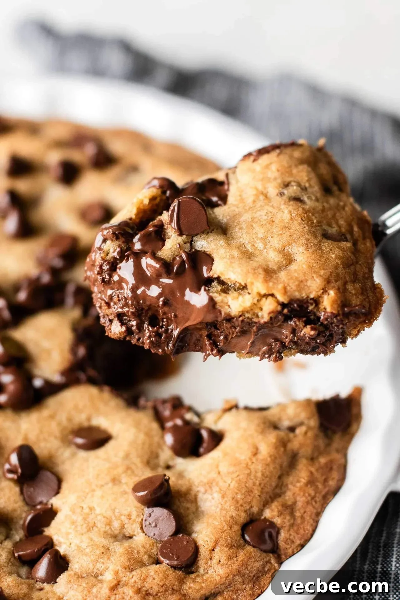 Giant Nutella-Stuffed Chocolate Chip Cookie Recipe 11 GIANT Nutella stuffed chocolate chip cookie with spoon full of cookie scooped out of dish