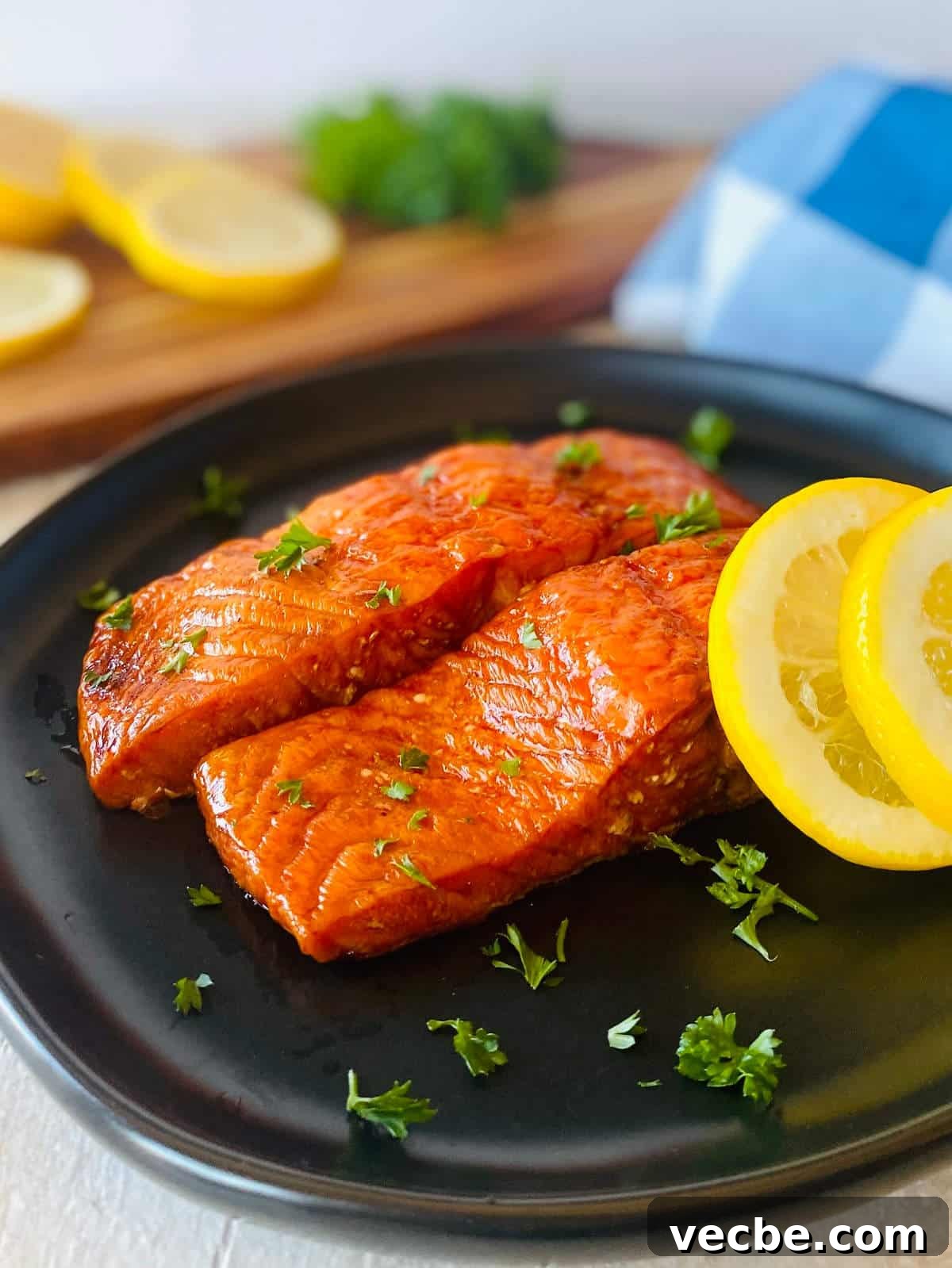How to Smoke Salmon on a Traeger for Smoky, Flaky Results 2 two smoked salmon filets on a plate with sliced lemons.