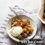 Gluten-Free Apple Recipes: 10+ Desserts, Snacks and More 11 Baked crisp with apples and butternut squash in a white bowl with a scoop of ice cream.