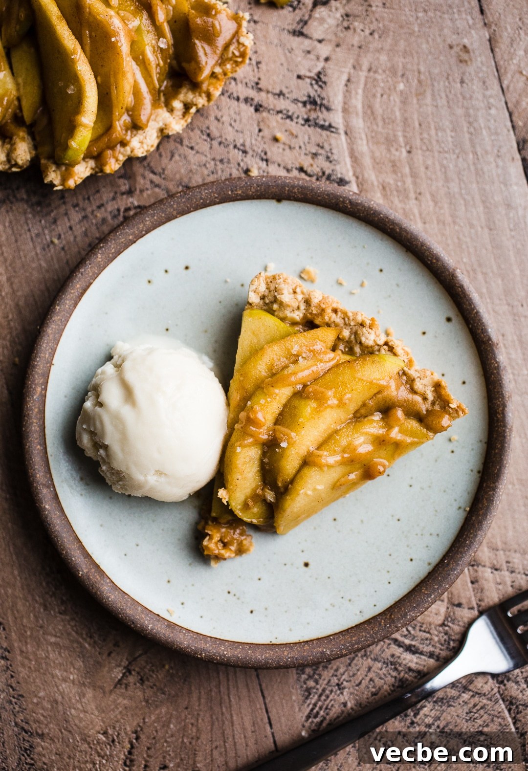 Gluten-Free Apple Recipes: 10+ Desserts, Snacks and More 8 A slice of apple tart with a scoop of ice cream on a rustic plate.