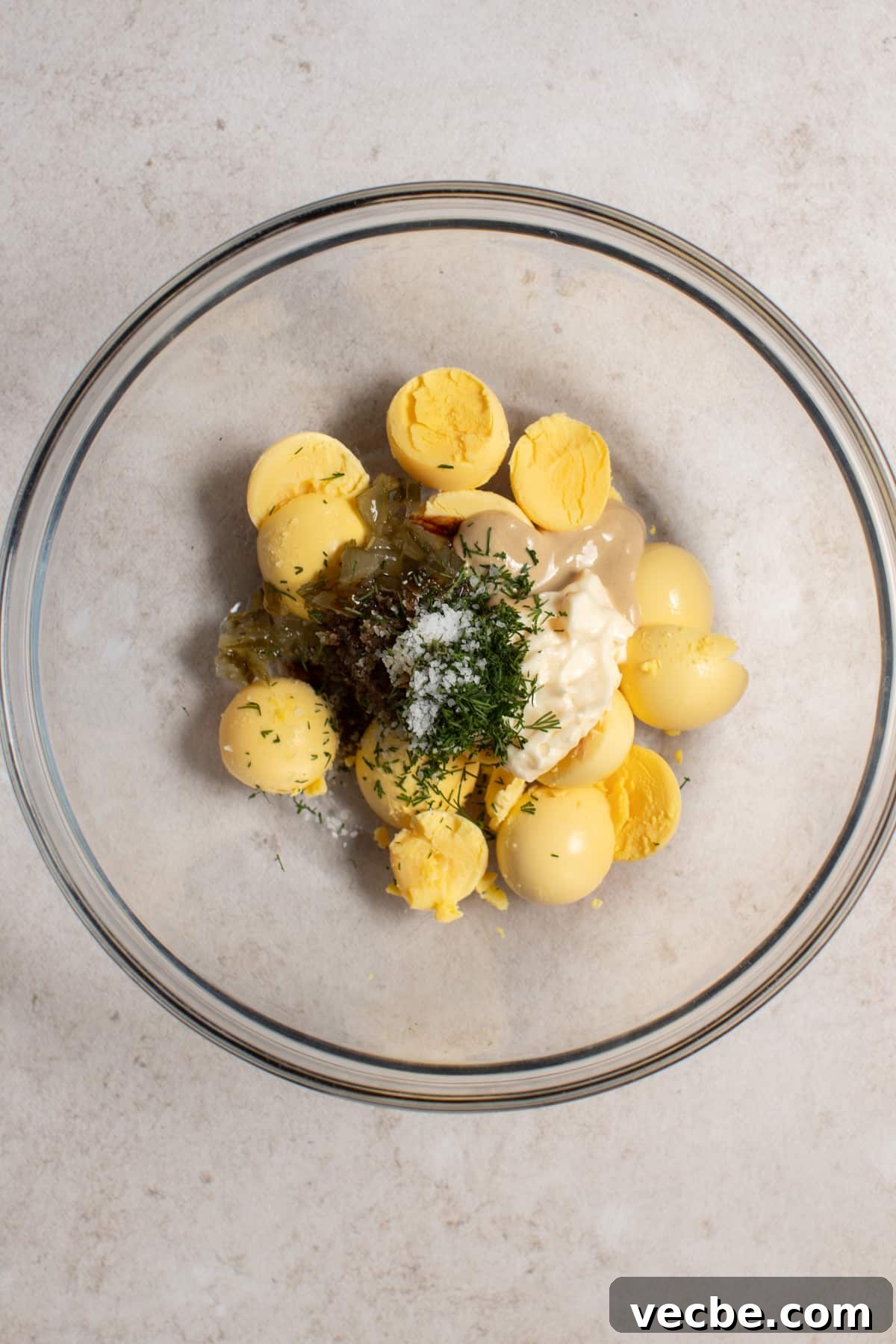 Crispy Candied Bacon Deviled Eggs 3 Egg yolks, mayo, relish, dijon mustard, dill, Worcestershire sauce, and salt in a bowl before mixing together to make the deviled egg filling.