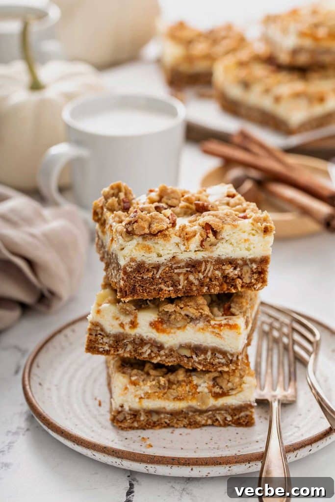 Pumpkin Cheesecake Bars with Creamy Swirl 14 Swirled pumpkin cream cheese bars stacked on a dessert plate.