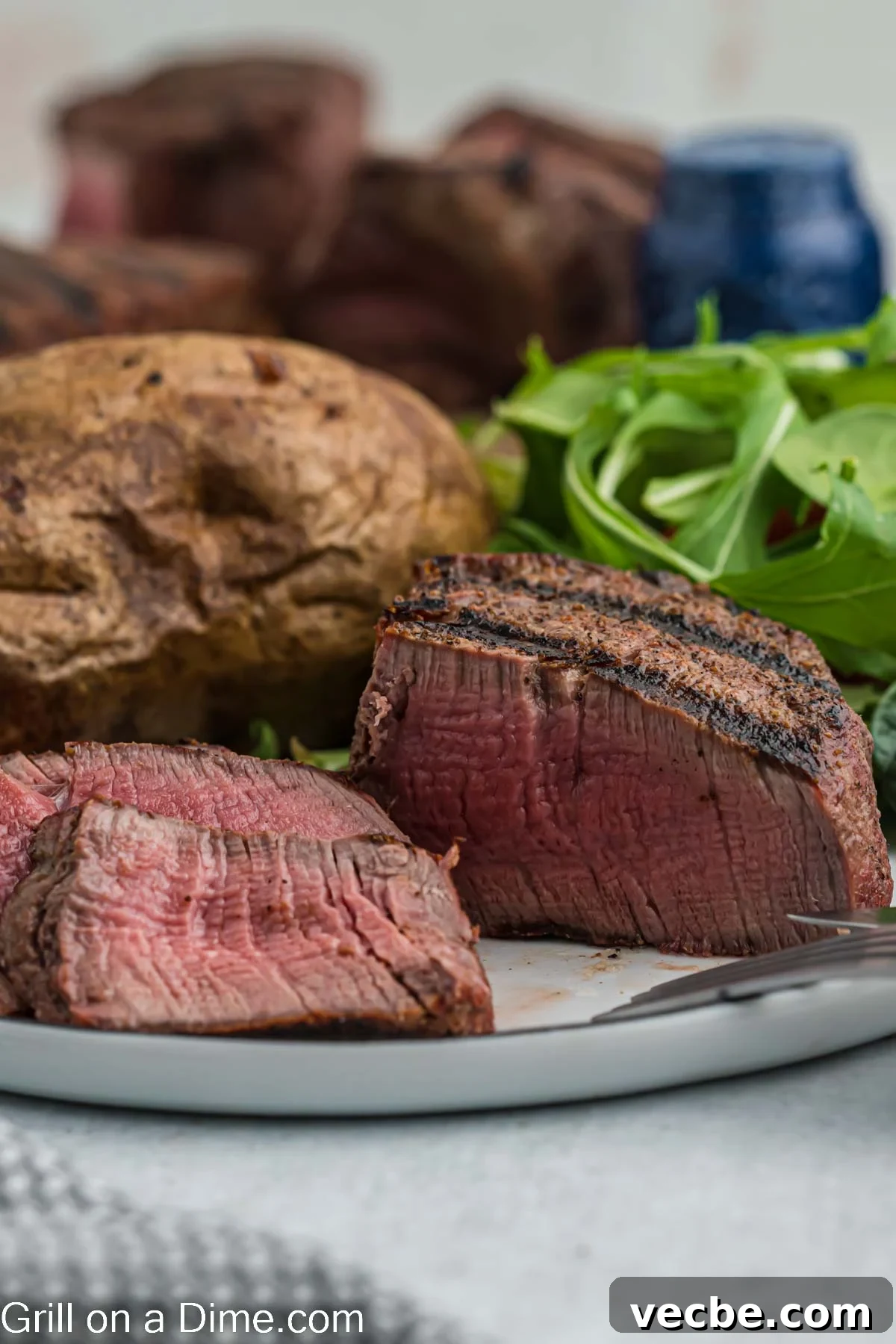 Grilled Filet Mignon Recipe: Tender, Juicy Steak 5 Filet Mignon on a plate with a baked potato and salad