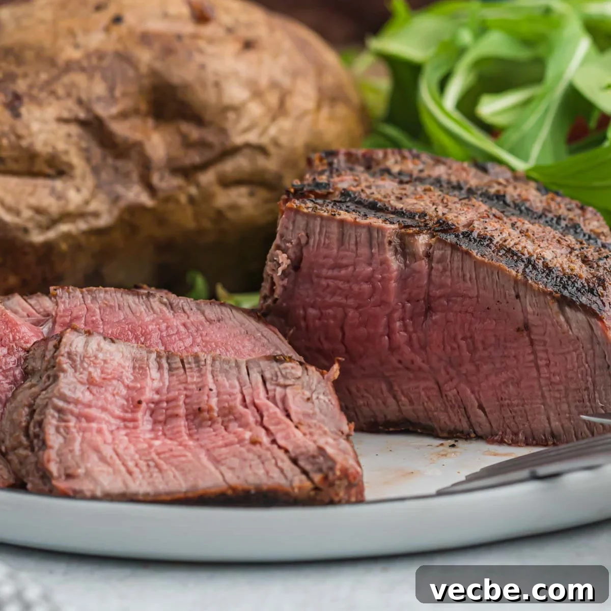 Grilled Filet Mignon Recipe: Tender, Juicy Steak 10 A steak on a plate with a side of potatoes.