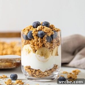 Homemade Peanut Butter Granola Recipe 7 Yogurt, sliced banana and granola parfait in a glass topped with blueberries.