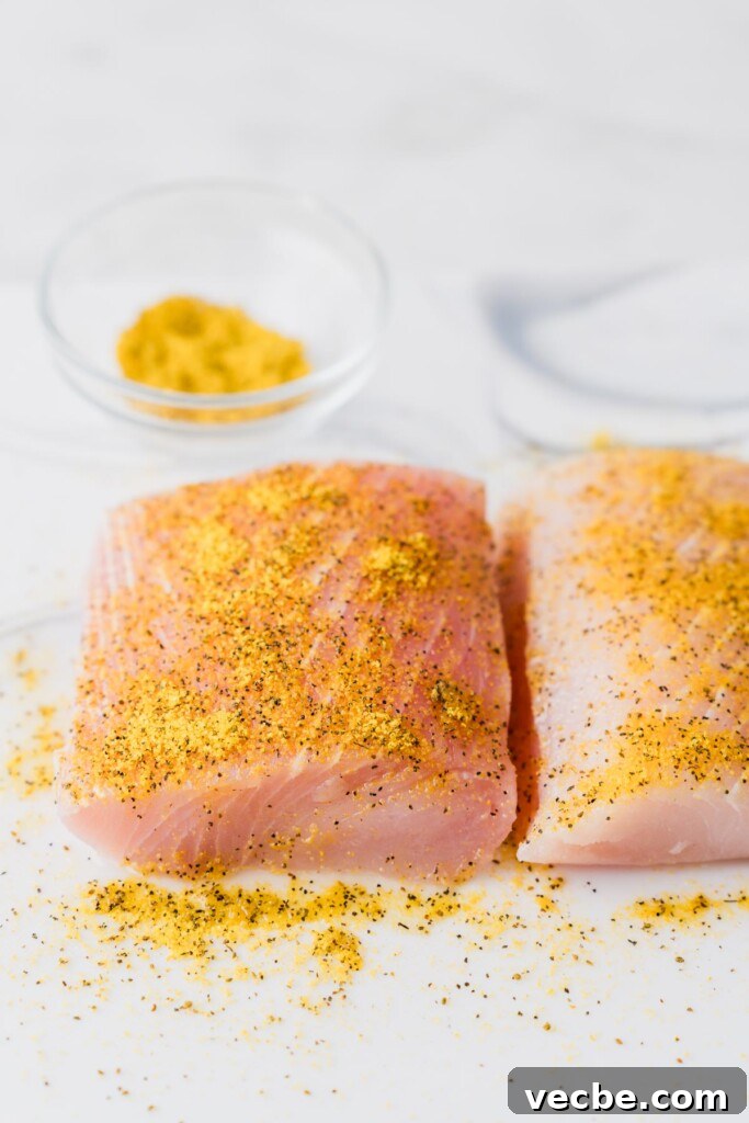 Air Fryer Mahi Mahi with Lemon Garlic 6 seasoned mahi mahi fillets on a board.