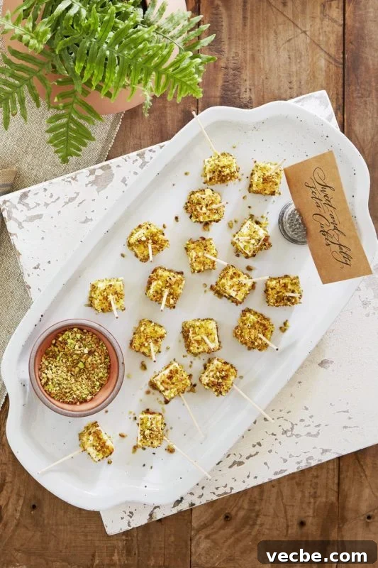 15 No-Bake Snack Recipes You Can Make in Minutes 12 Cubes of feta cheese skewered coated in pistachios on a white plate