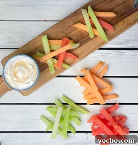 15 No-Bake Snack Recipes You Can Make in Minutes 16 Sticks of melon in piles on cutting board with yogurt dip on the side.