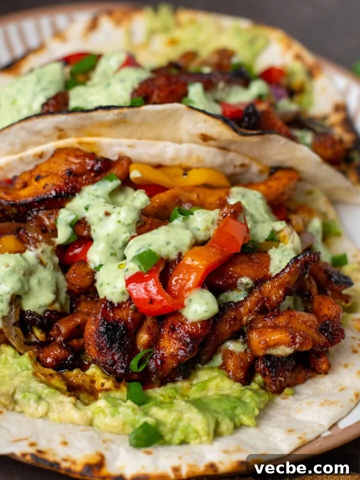 Caramelized Chipotle Chicken Fajitas Recipe 15 close up view of chipotle chicken topped with fajita veggies and cilantro sauce