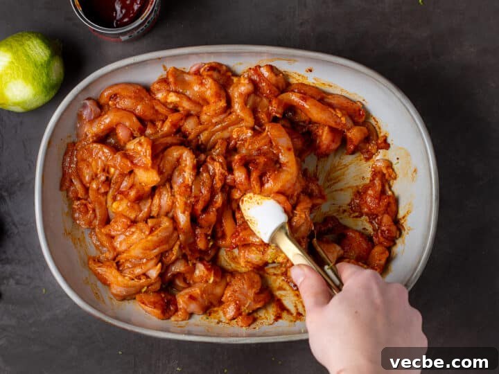 Caramelized Chipotle Chicken Fajitas Recipe 10 hand using tongs to toss chicken in marinade
