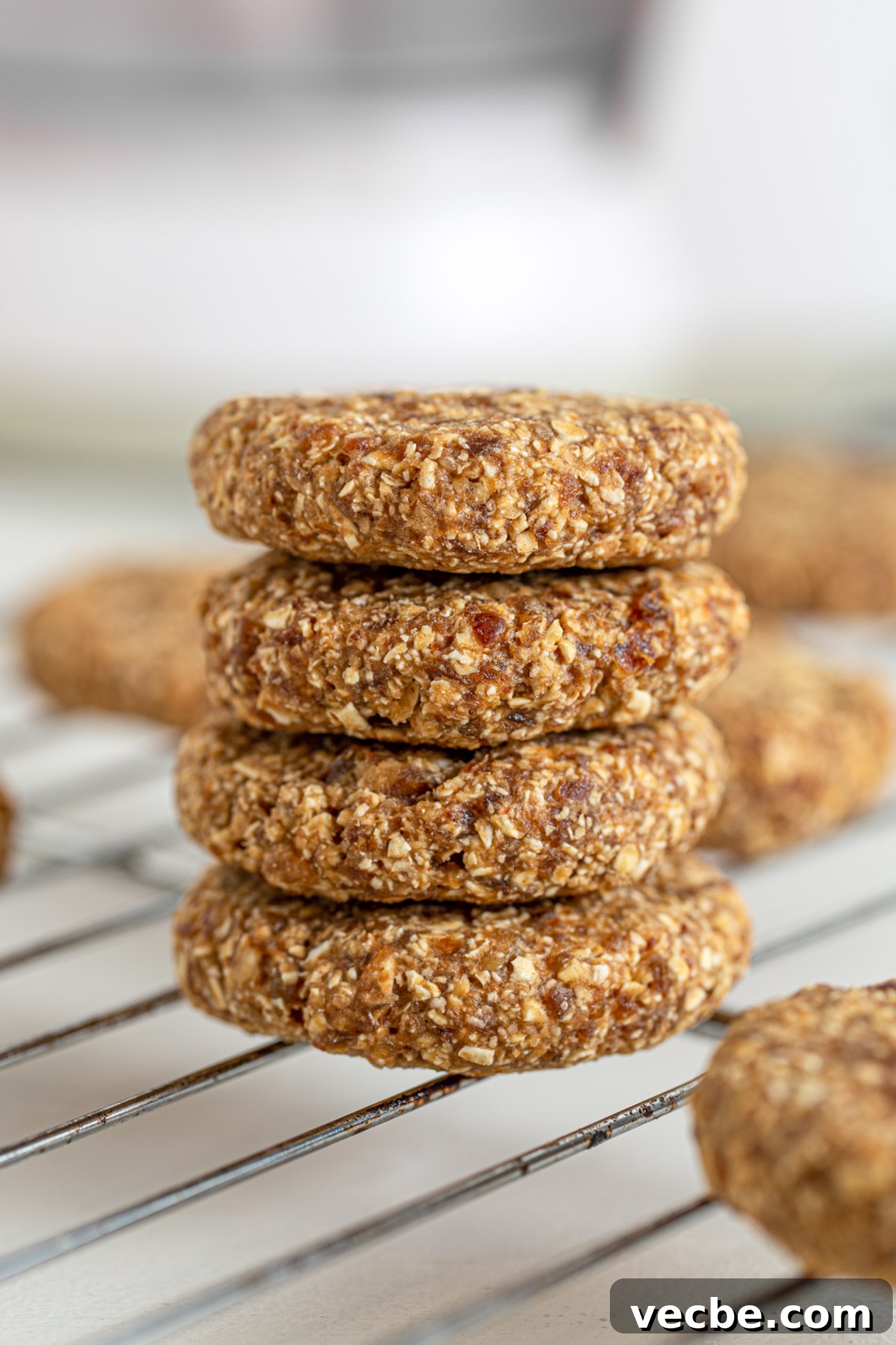 Vegan Tahini Date Cookies Recipe 2 Stack of 4 tahini date cookies sitting on a cooling rack.