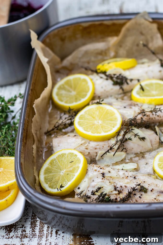 Baked Mahi Mahi with Fresh Blueberry Sauce 6 A roasting pan of baked mahi mahi. Lemon slices and thyme sprigs sit on top of the fish.