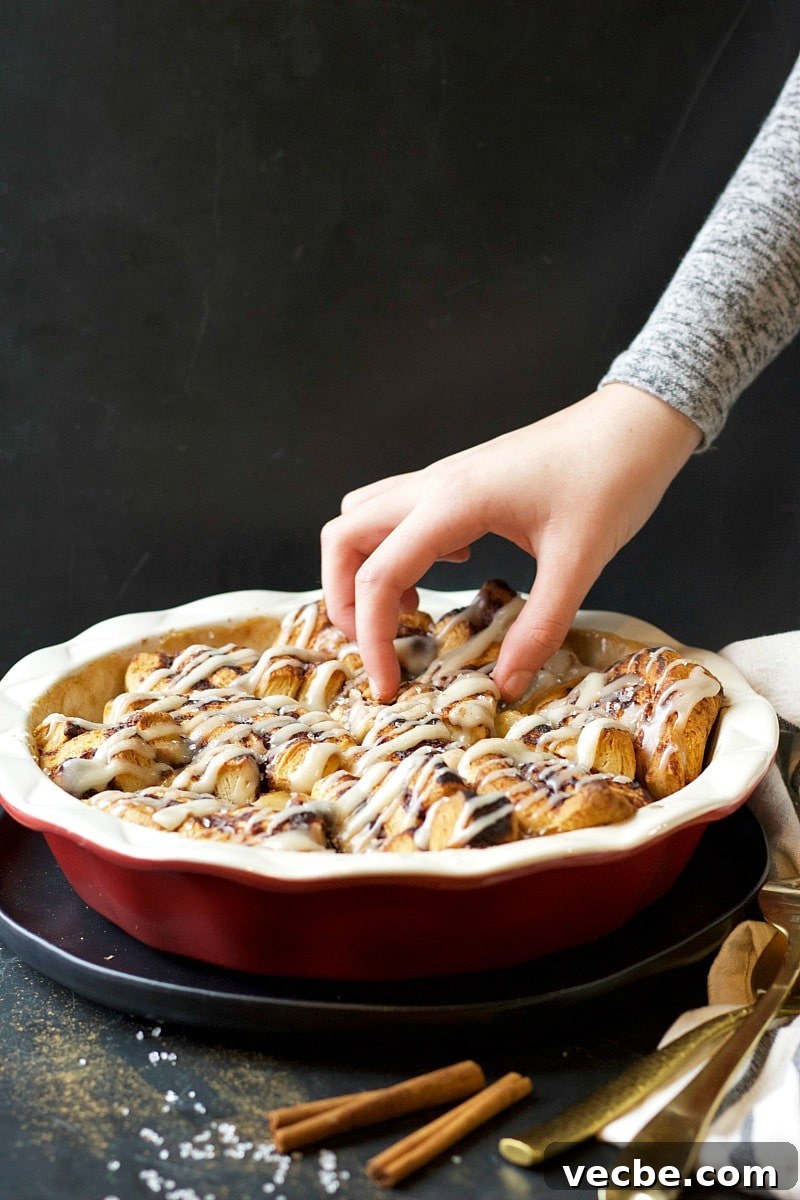 Mini Cinnamon Apple Cobbler Bites 3 Cinnamon Bites Apple Cobbler in a red dish, cinnamon sticks, and spoons.