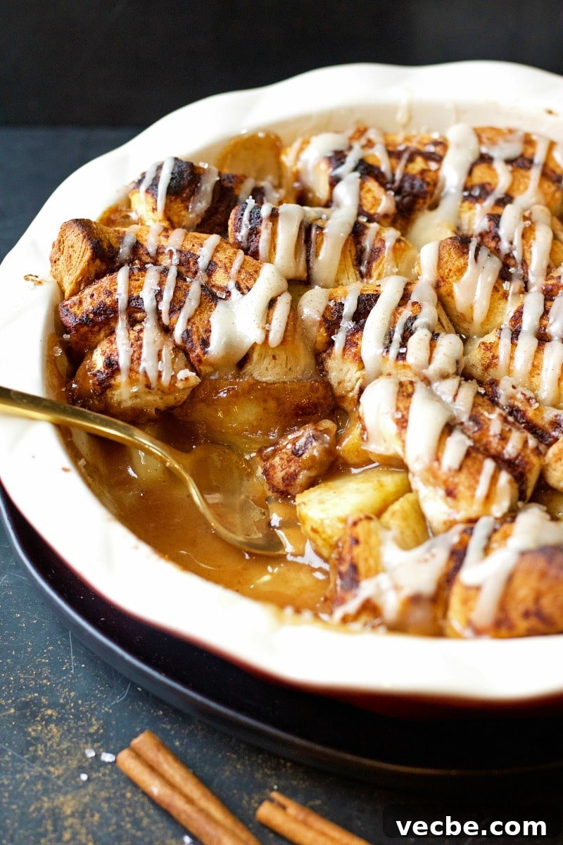 Mini Cinnamon Apple Cobbler Bites 6 Cinnamon Bites Apple Cobbler in a white rimmed dish with a spoon, and cinnamon sticks.