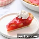 No Bake Strawberry Jello Pie Recipe 13 a slice of strawberry jello pie on a plate topped with homemade whipped cream.
