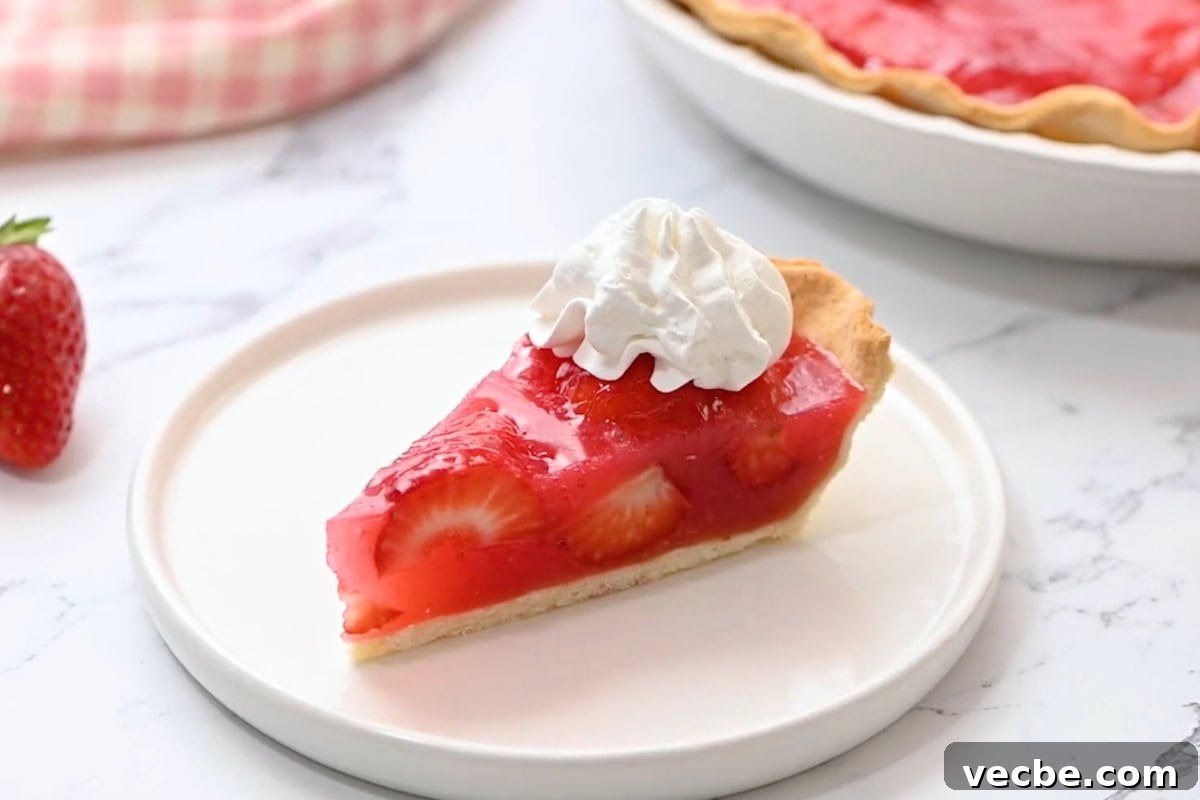No Bake Strawberry Jello Pie Recipe 20 a slice of strawberry jello pie on a plate topped with homemade whipped cream.