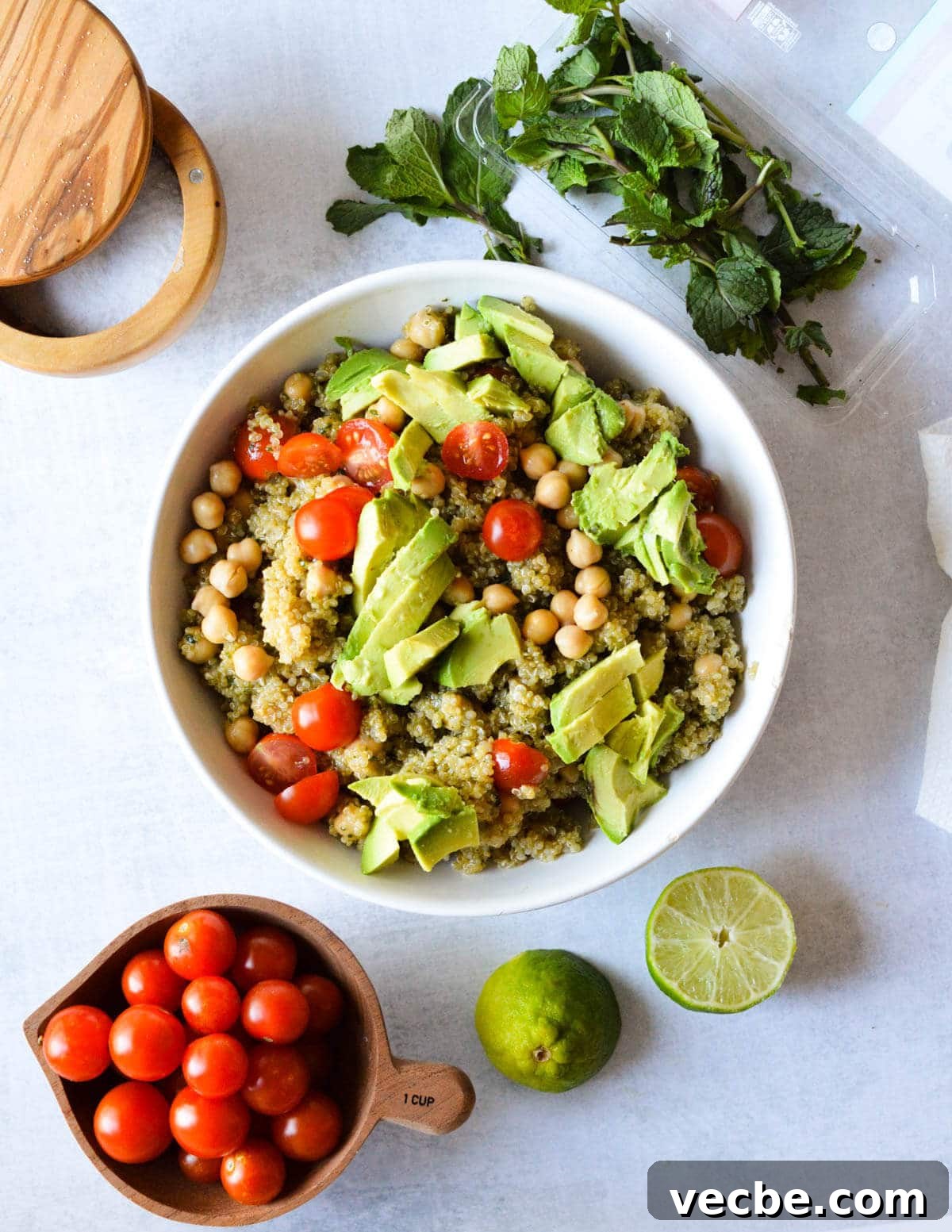 Herbed Quinoa Salad with Avocado and Chickpeas 10 a bowl of quinoa salad with chickpeas, avocado, and cherry tomatoes.