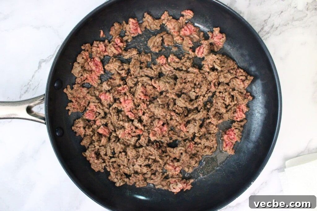 Crispy Air Fryer Ground Beef Nachos for Game Day 5 partially brown ground beef in skillet