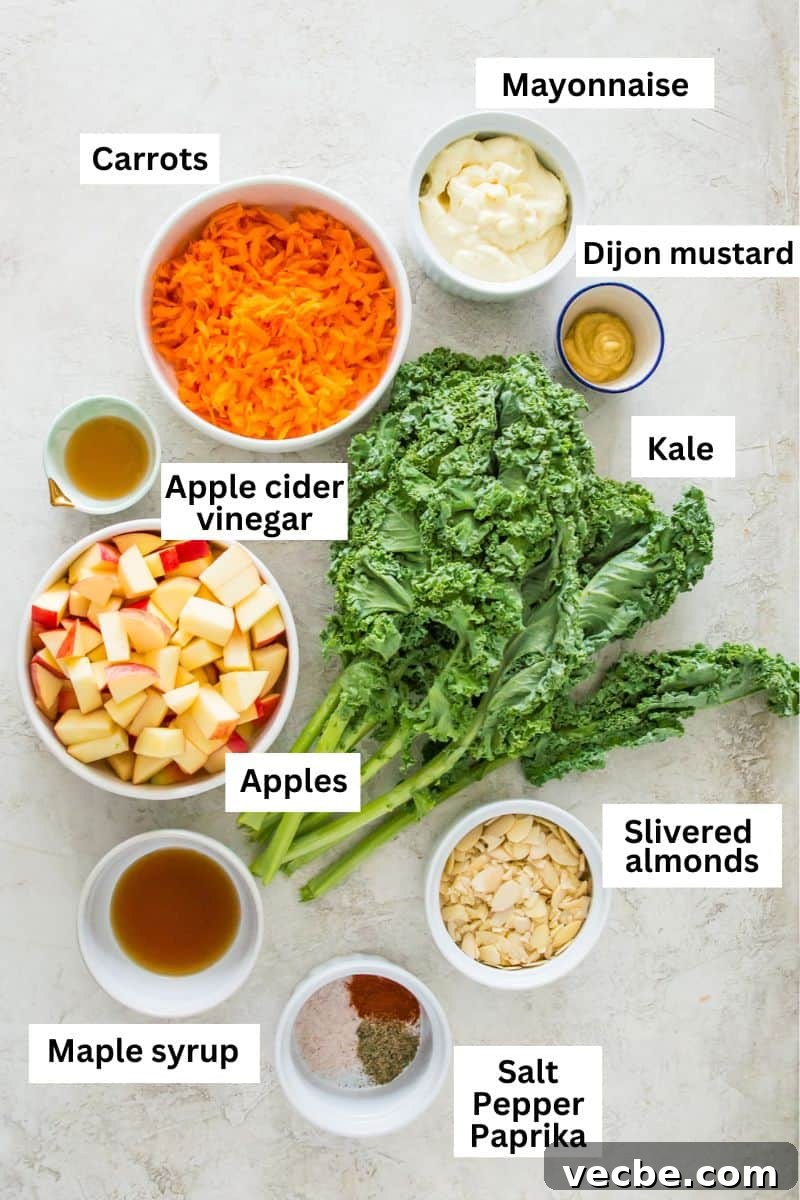 Cabbage-Free Kale Slaw with Apples and Carrots 2 The ingredients needed to make a kale and apple salad separated into bowls including fresh kale, shredded carrots, chopped apples and mayonnaise.