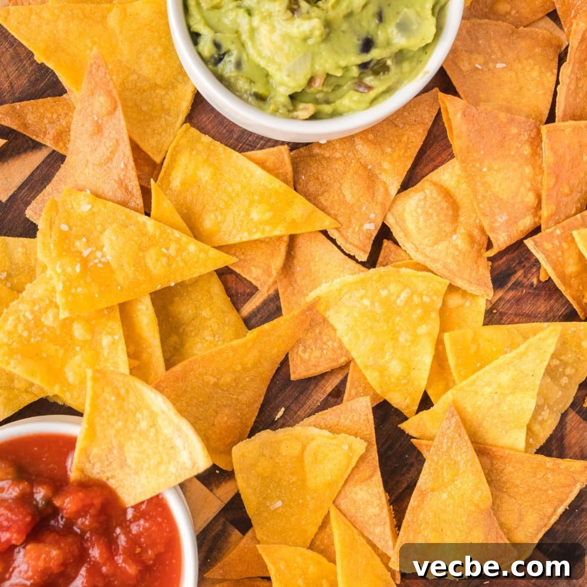 Crispy Baked Corn Tortilla Chips Recipe 8 Close up top down view of homemade corn tortilla chip surrounding a bowl of salsa - Hostess At Heart