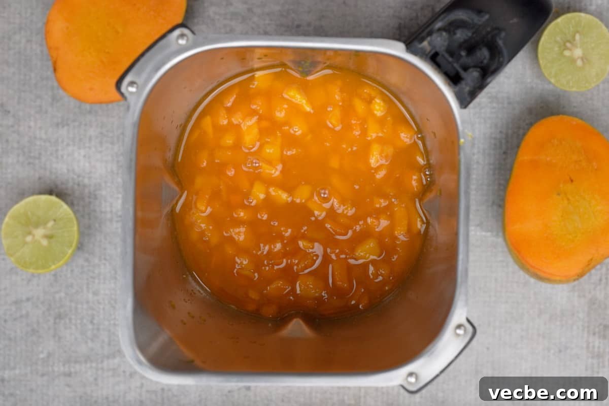 Mango Coulis Recipe: Silky Sweet Sauce for Desserts 7 Mango mixture added to a blender.