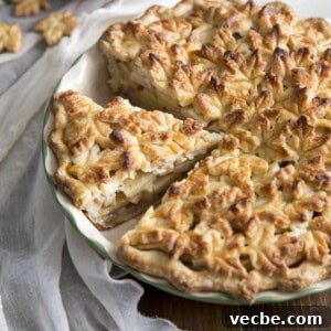 Apple Pie with a Maple Leaf Crust 12 A sliced apple pie with maple leaf crust in a pie dish.