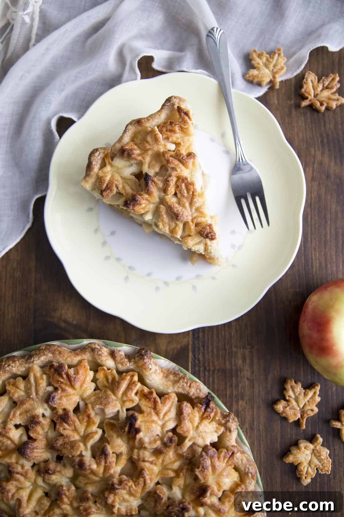 Apple Pie with a Maple Leaf Crust 3 A slice of Apple Pie on a plate next to a fork.