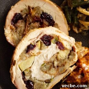 Apple Cranberry Stuffed Turkey Breast Recipe 8 A close up view of the sliced turkey breast on a plate. You can see the stuffing with the apples and dried cranberries swirled in the turkey.