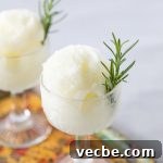 Lemon Rosemary Sorbet Recipe 2 Glass with a scoop of sorbet garnished with a rosemary sprig.
