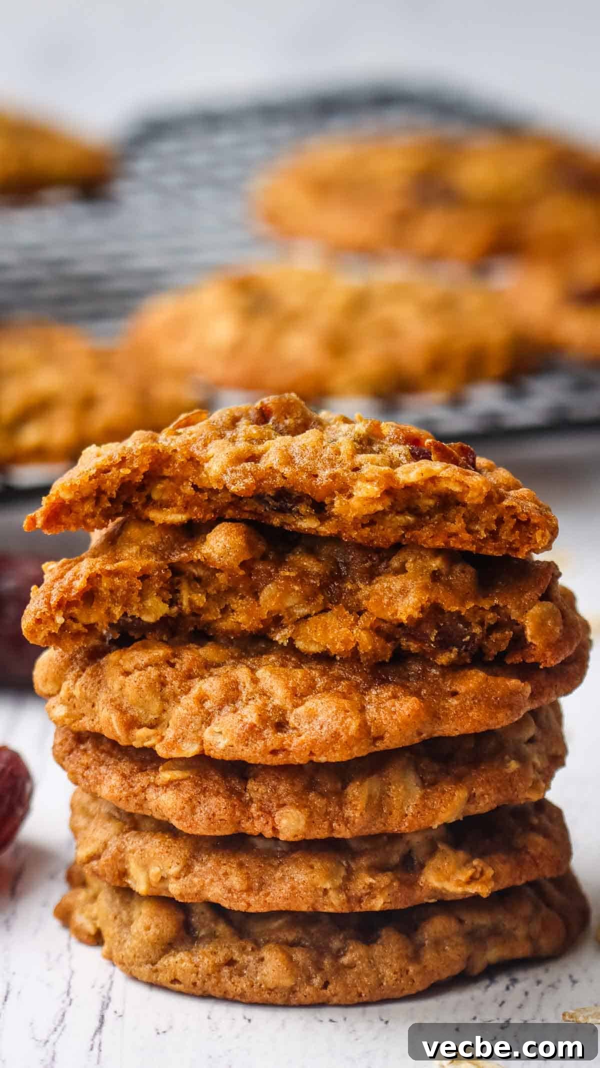 Chewy Date Oatmeal Cookies with Cinnamon 8 A stack of oatmeal date cookies with the one on top broken in half to show the inside.