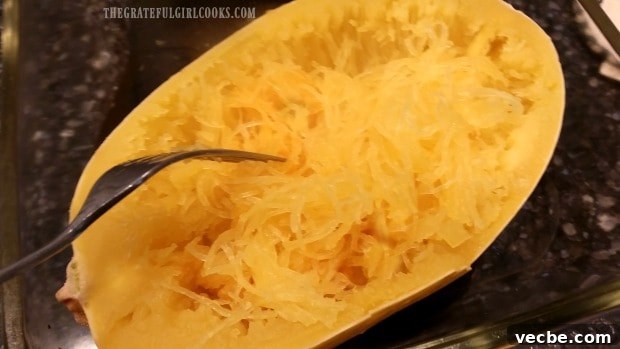 How To Cook Spaghetti Squash Fork shredding cooked spaghetti squash into noodle-like strands