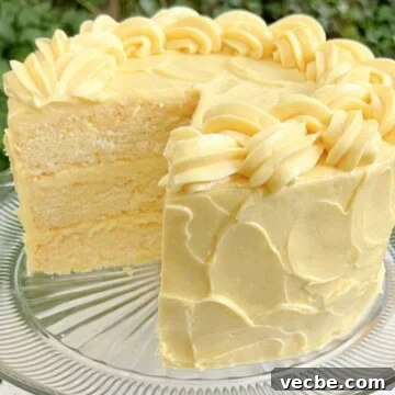 Lemonade Layer Cake Recipe with Bright Lemon Frosting 14 Lemonade Layer Cake, sliced, on a cake pedestal.