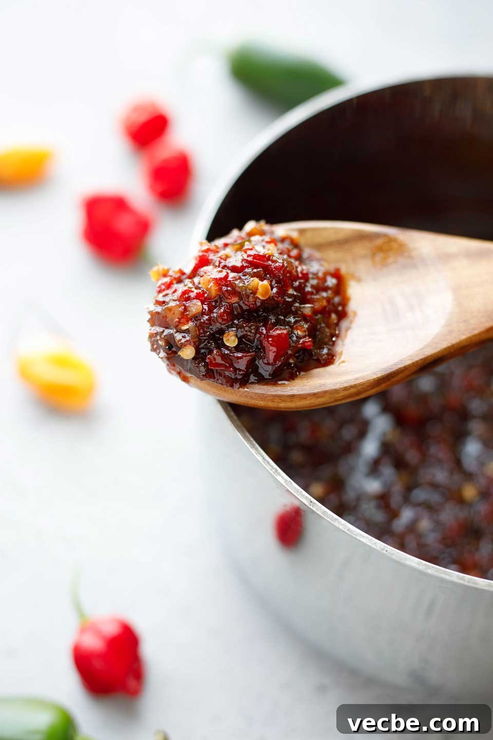 Homemade Sweet and Spicy Pepper Relish Recipe 8 Closeup of wooden spoonful of cooked pepper relish, laid across the cooking pot.