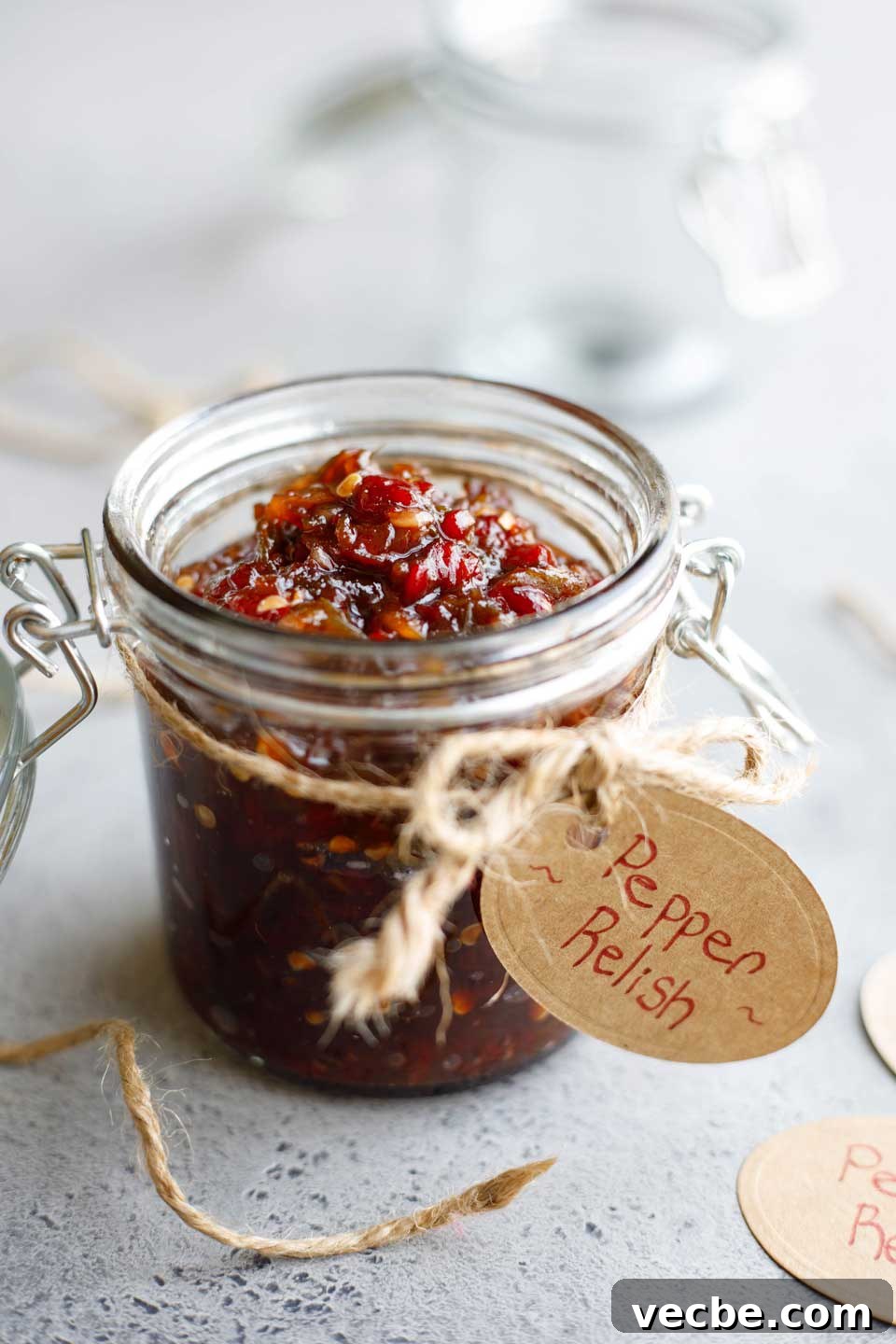 Homemade Sweet and Spicy Pepper Relish Recipe 10 Recipe presented in a canning jar with brown string tied around and a gift tag reading "Pepper Relish".