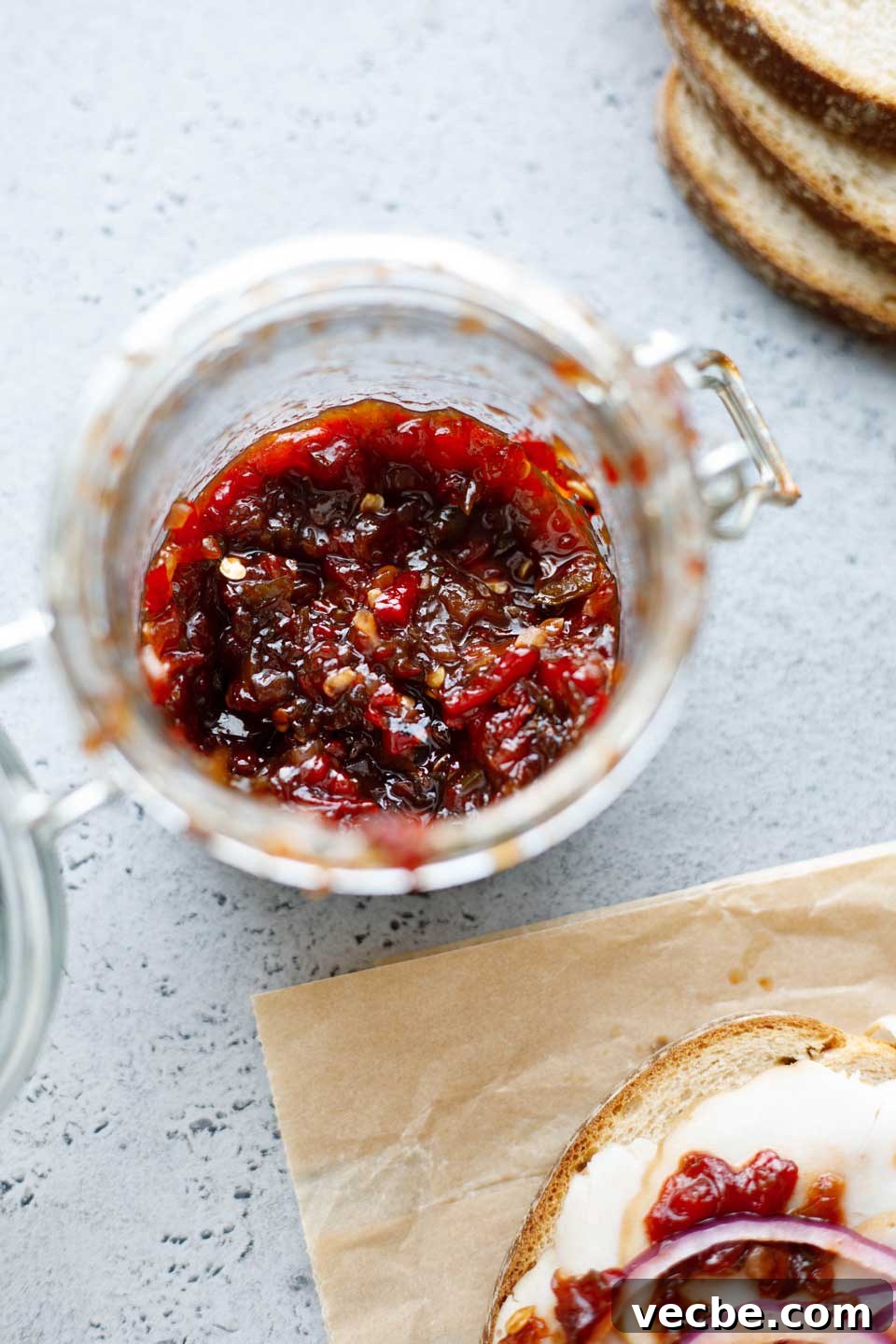Homemade Sweet and Spicy Pepper Relish Recipe 5 Overhead of partially empty jar of pepper relish, with sandwich ingredients that it's a topping for.