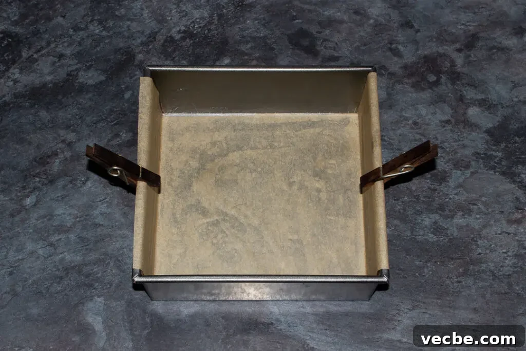 Red Velvet Millionaire Brownies Recipe with Caramel and Chocolate 11 A square baking tin lined with baking paper and held on by two pegs