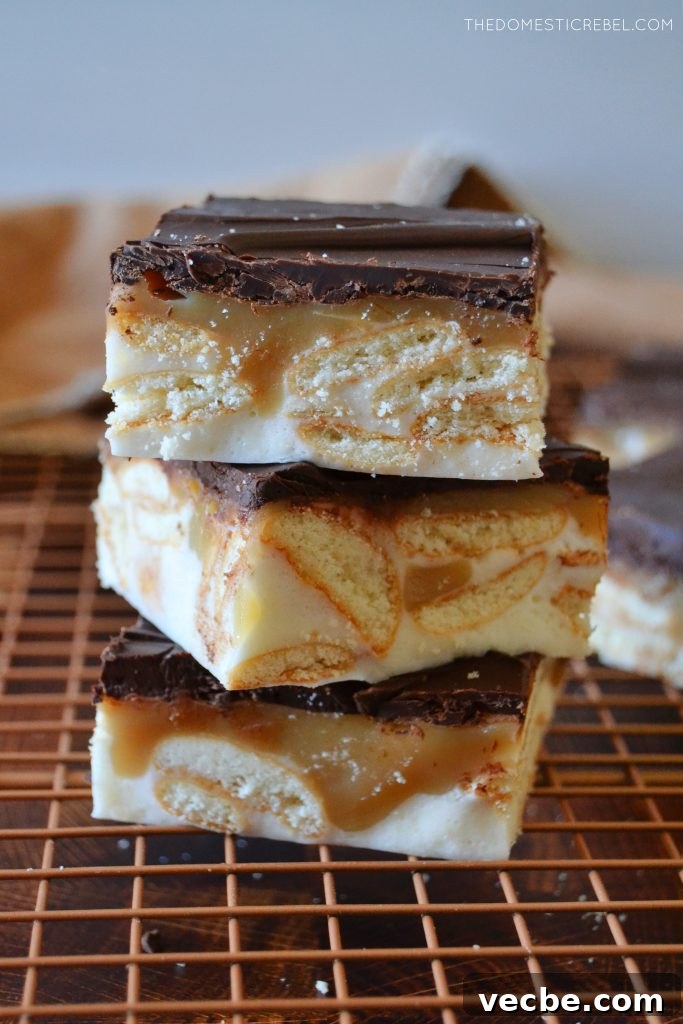 No-Bake Marshmallow Twix Bars Recipe 4 a trio vertical stack of marshmallow twix bars on a wire rack