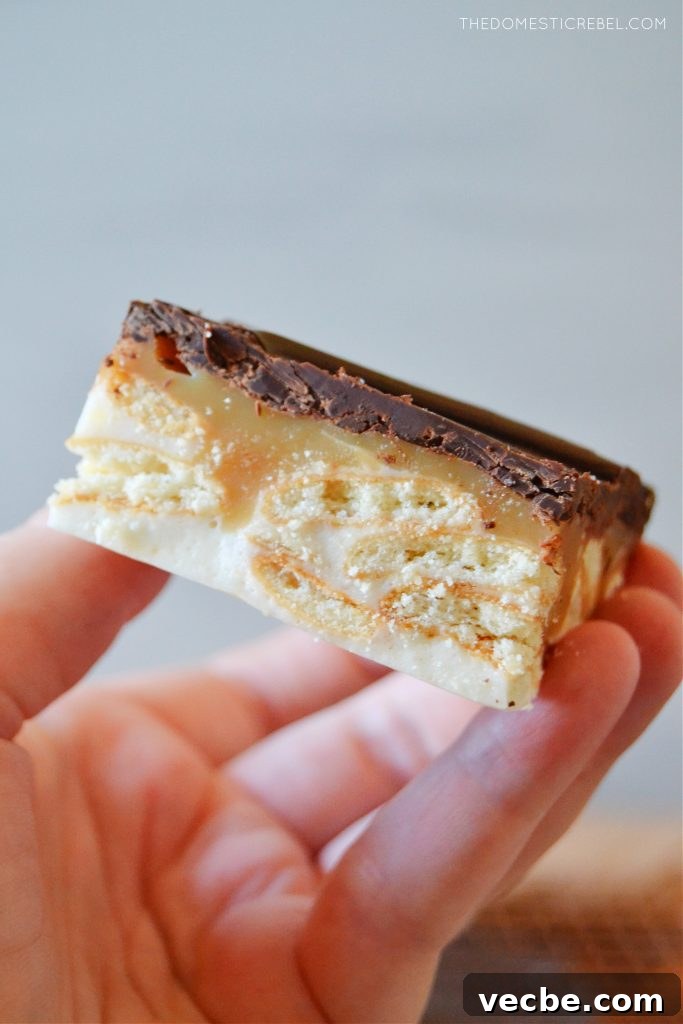No-Bake Marshmallow Twix Bars Recipe 7 author holding a marshmallow twix bar