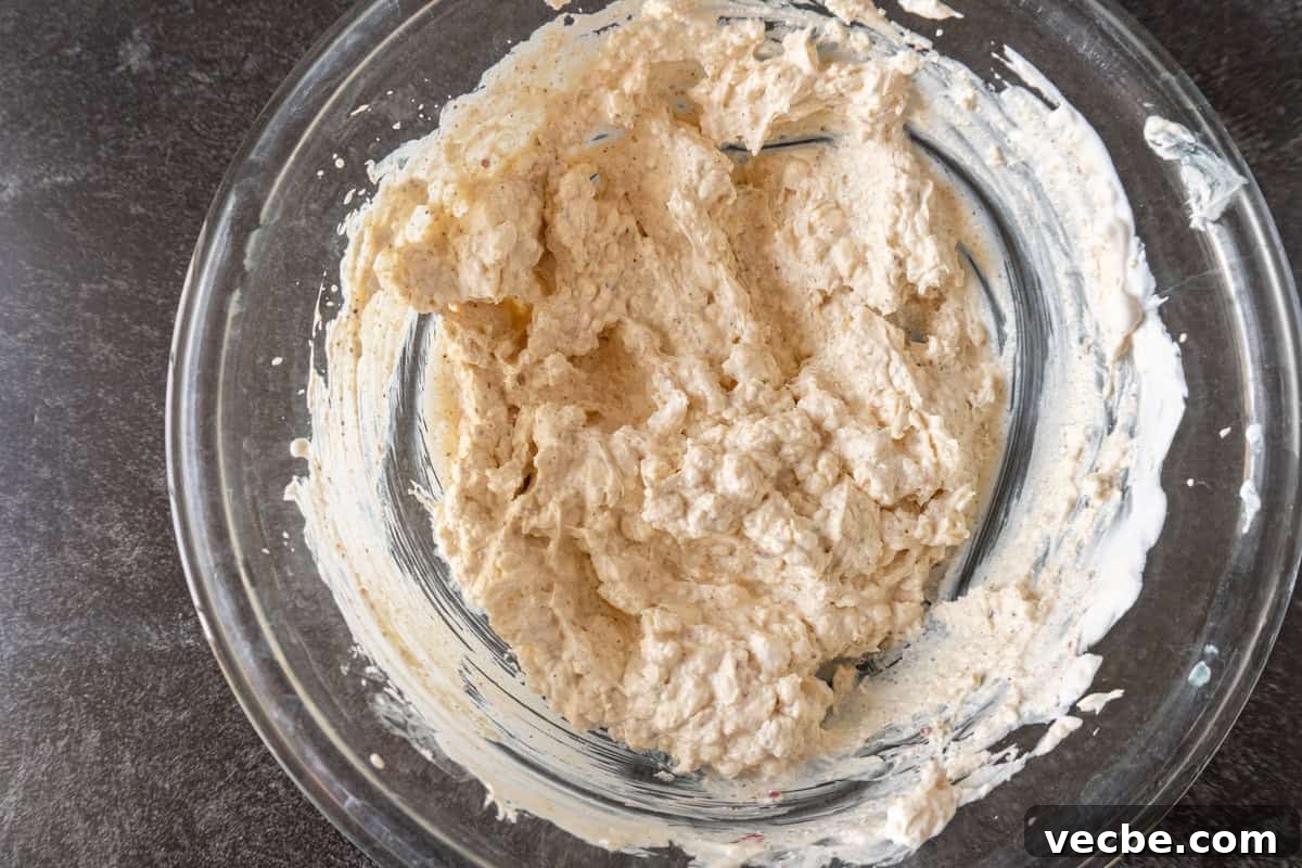 Creamy Hot Artichoke Dip Recipe 6 artichoke dip base mixed together in a glass bowl.