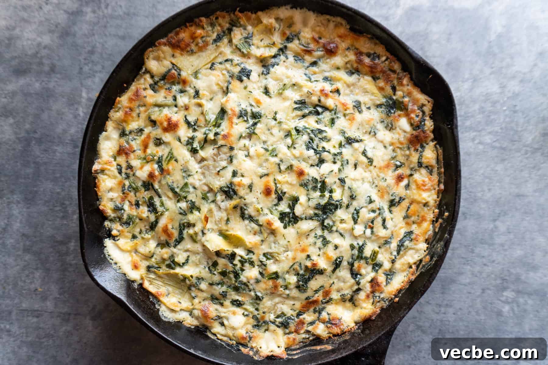 Creamy Hot Artichoke Dip Recipe 8 hot artichoke dip baked in a cast iron pan with golden top.