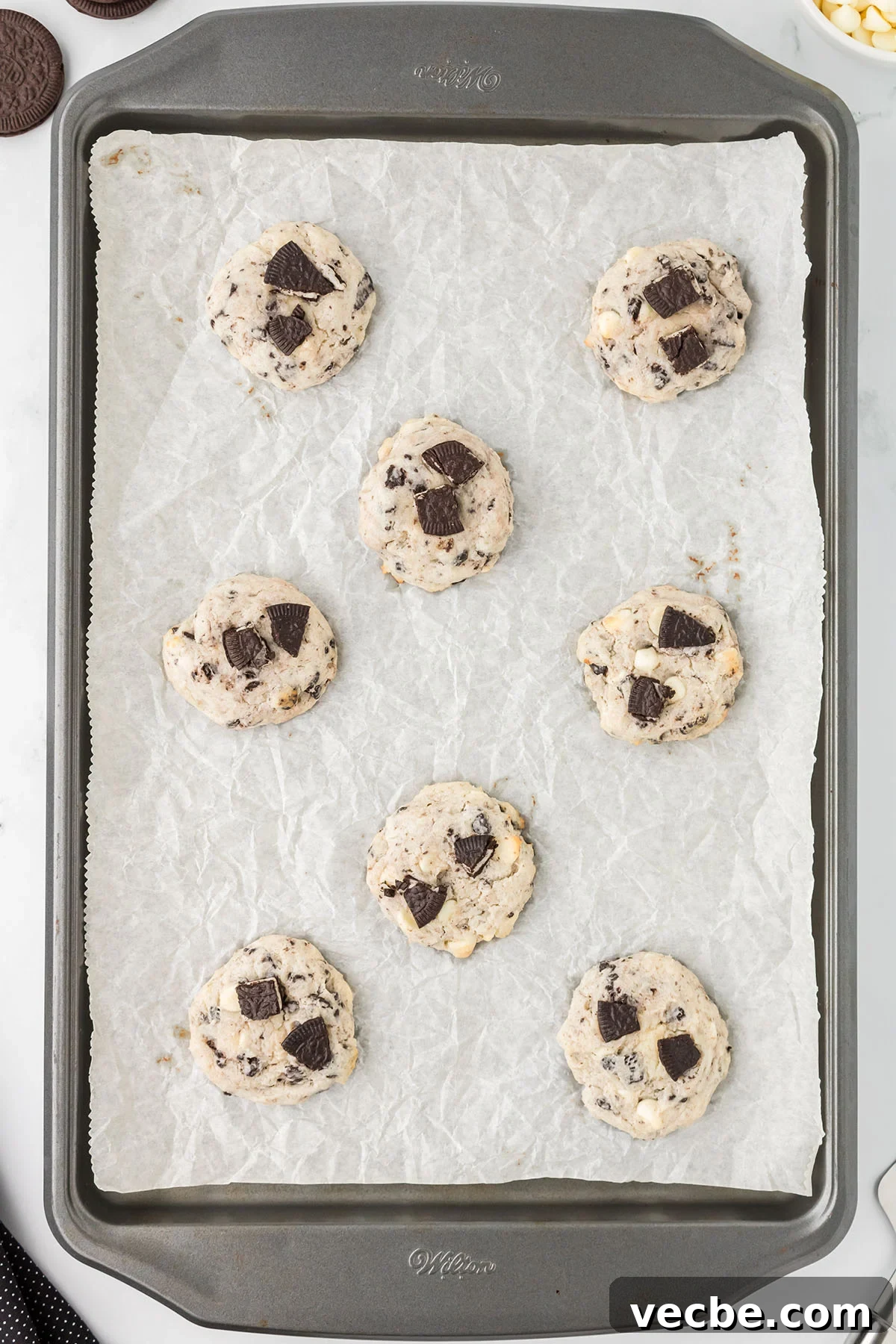 Cookies and Cream Cheesecake Cookie Bites 9 Baked cookies on a parchment paper lined baking sheet.