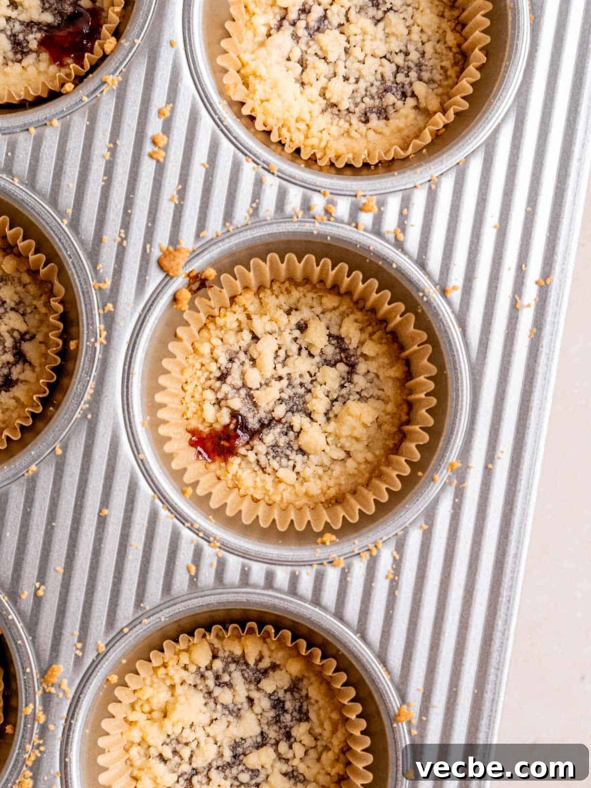 Raspberry Crumble Cookies Better Than Costco 9 Shortbread cookies with raspberry filling in a muffin pan.