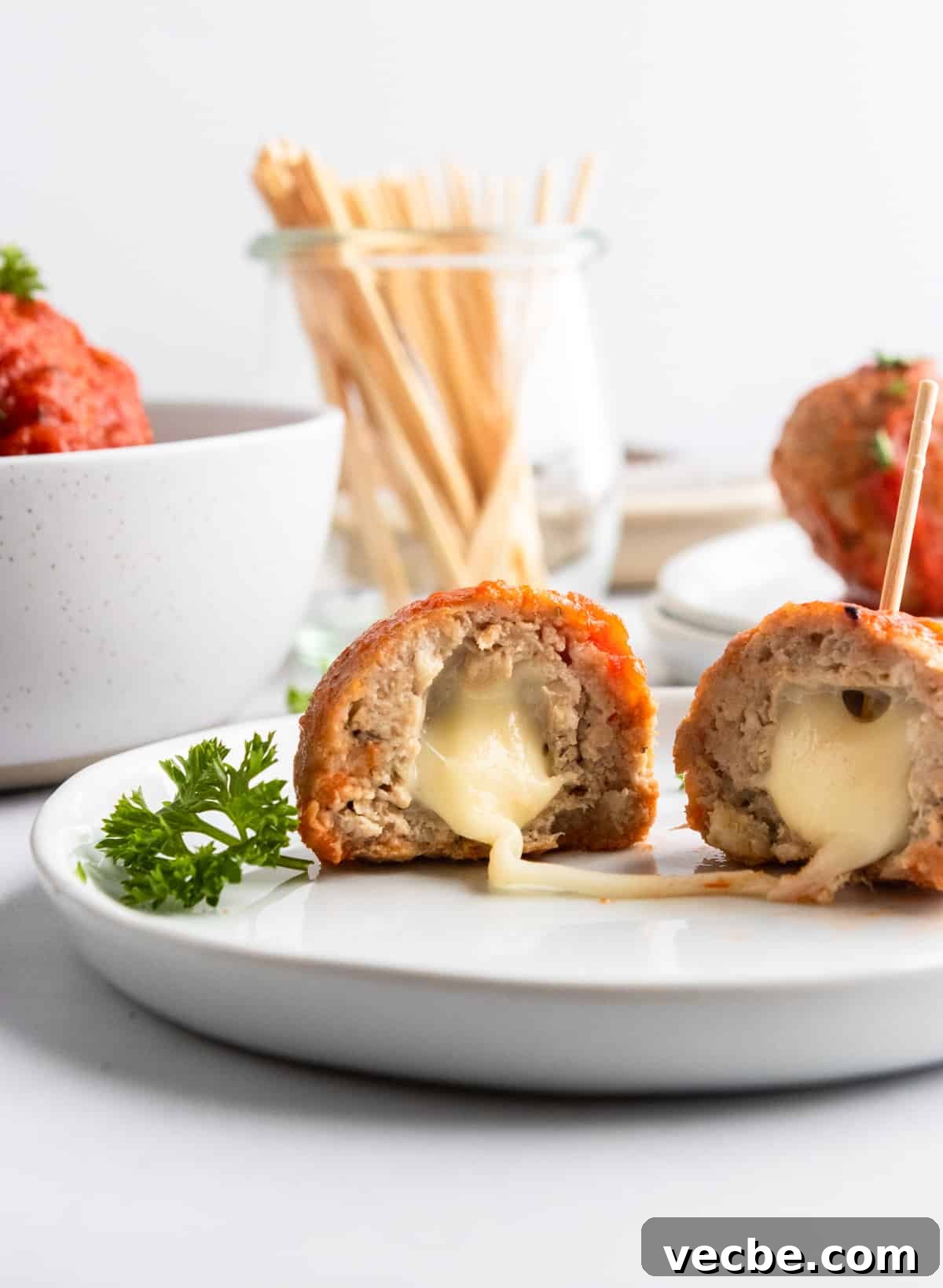 Mozzarella Stuffed Turkey Meatballs Recipe 2 Mozzarella stuffed meatballs on plate.